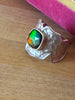 Side view of ammolite sterling silver ring showing cushion-shaped gemstone and sculptural hammered band