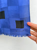 Close-up of vintage Echo silk scarf showing cobalt blue black geometric squares and fringe. 
