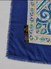 Close-up of ornate teal cream and blue paisley medallion pattern and "art of the scarf, made in italy" tag
