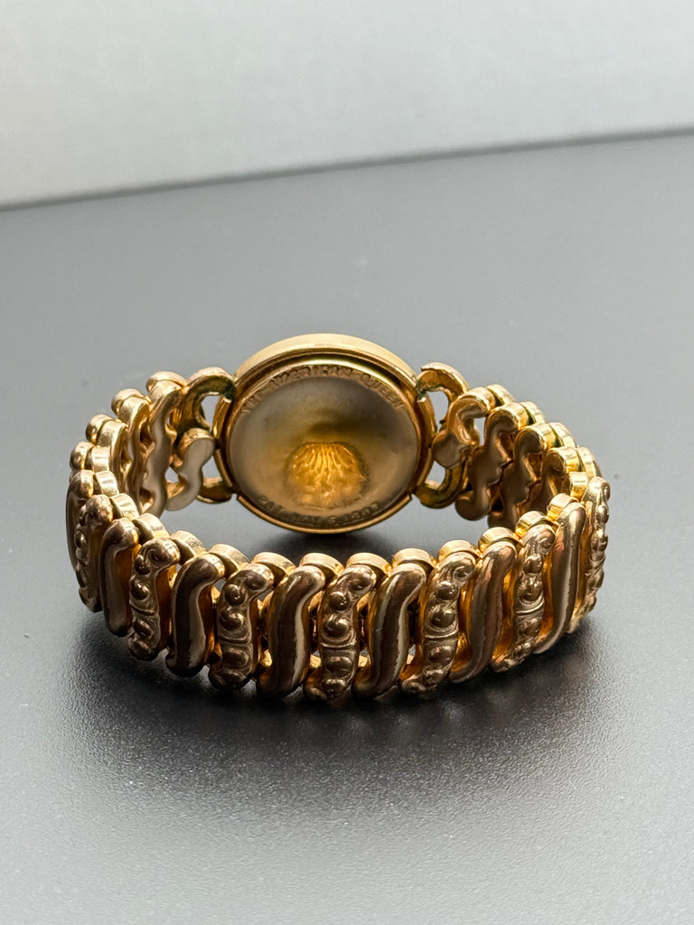 Vintage gold filled expansion bracelet showing decorative textured S scroll links. 