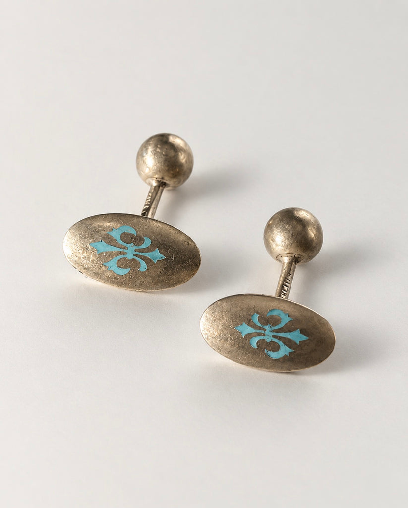 Pair of turquoise enamel fleur-de-lis cufflinks showing oval silver fronts