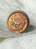 Close-up of copper-toned Nepal coin with detailed lettering and imagery in sterling silver ring