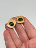Matching pair of vintage gold-tone cufflinks with polished oval green cabochons held in hand