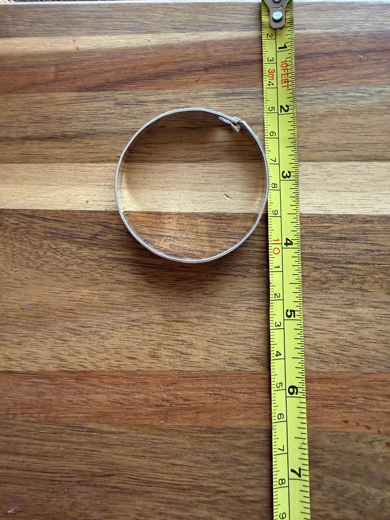 Northwest Coast silver bracelet beside measuring tape showing size