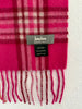 Close-up of fuchsia pink plaid cashmere scarf showing designer label and fringe