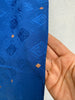 Close-up of cobalt blue silk scarf showing small gold geometric accents. 