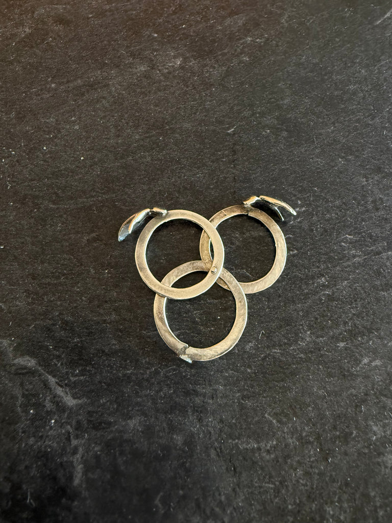 Three-piece sterling silver Gimmel ring separated to show interlocking band construction
