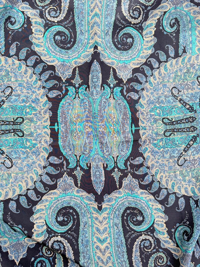 Close-up of intricate turquoise and navy paisley pattern on silk scarf