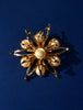 Vintage floral brooch with cream faux pearls and dimensional gold-tone petals