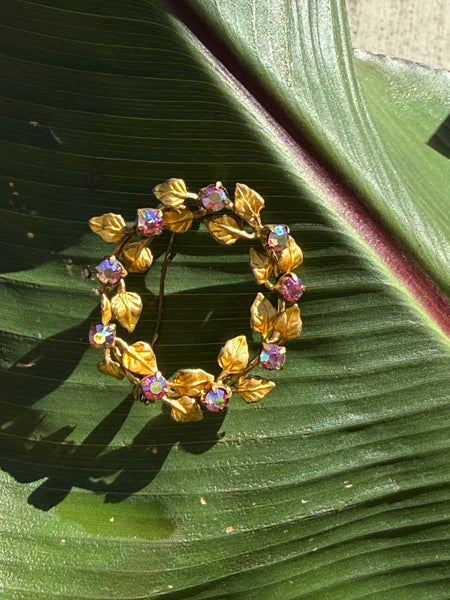 Vintage Austrian Aurora Borealis crystal wreath brooch with iridescent stones and textured gold-tone leaves
