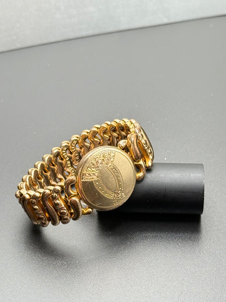 Antique American Queen gold-filled sweetheart expansion bracelet by Pitman & Keeler with engraved floral medallion and ornate S-scroll links. 