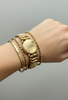 Antique WWII-era heart bracelet styled on the wrist with an unmonogrammed engraved medallion, warm gold tones and decorative expansion links. 