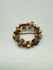 Angled view of gold-tone Austrian wreath brooch showing Aurora Borealis crystal clusters