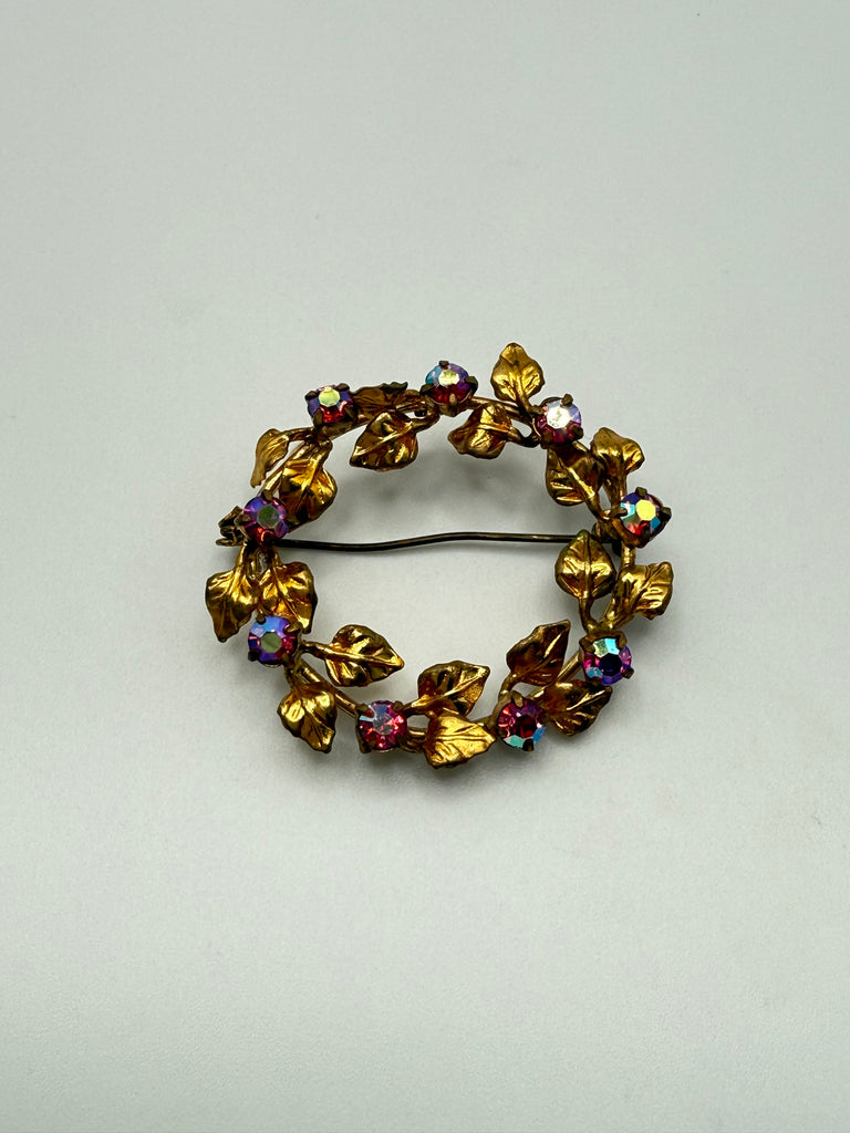 Angled view of gold-tone Austrian wreath brooch showing Aurora Borealis crystal clusters