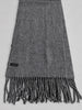Detail of charcoal grey Enzo Mantovani cashmere scarf showing fabric texture and fringe