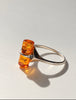 Close-up of cognac Baltic amber cylinder in open silver ring setting