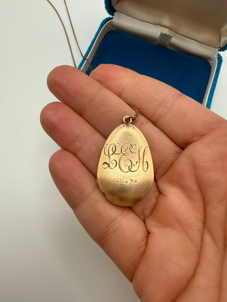 Back of vintage gold-filled locket showing engraved initials and date 11 11 75