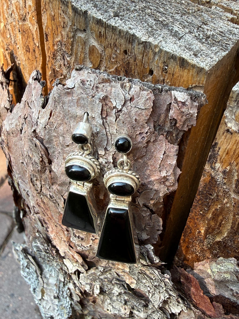 Black onyx and sterling silver dangle earrings photographed on natural wood