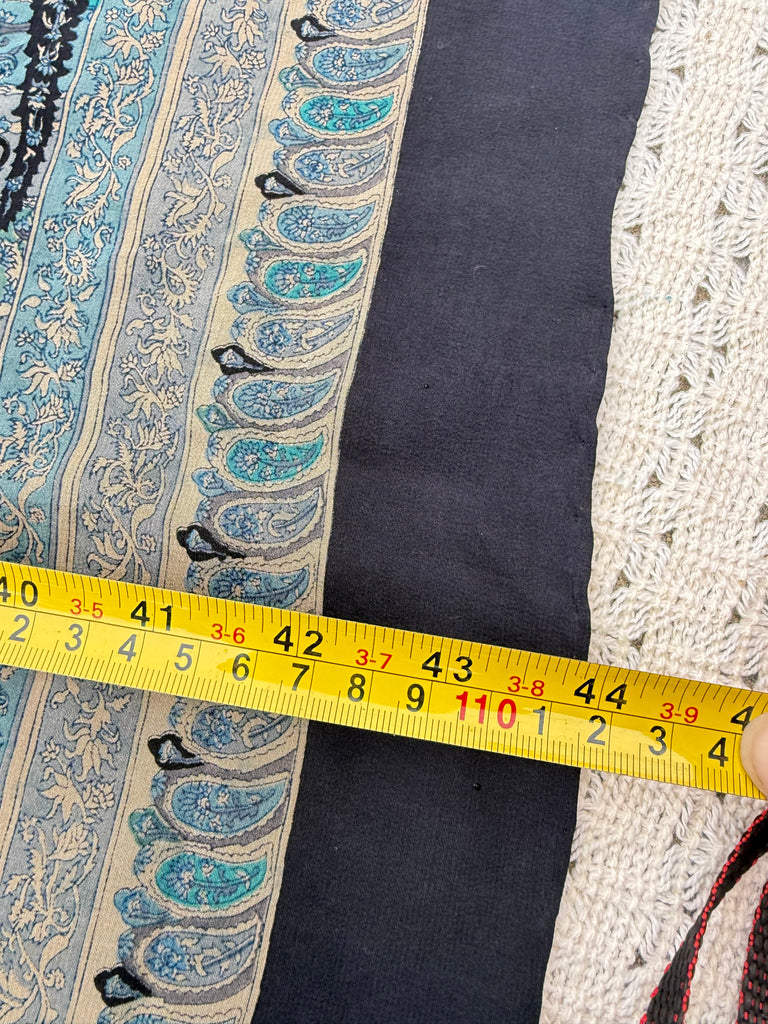 Measuring tape beside turquoise vintage silk scarf showing dimensions