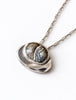 Close-up of oval grey and brown banded agate cabochon in sculptural silver setting