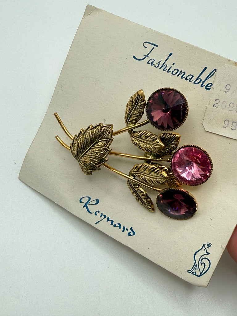 Vintage Austrian pink and purple crystal floral brooch displayed on original Made in Austria card