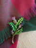 Vintage Scottish thistle enamel brooch pinned to tartan fabric
