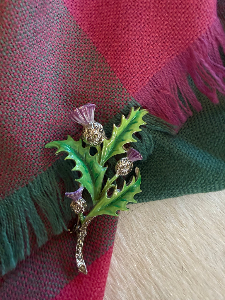 Vintage Scottish thistle enamel brooch pinned to tartan fabric