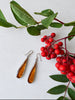 Mexican 925 sterling silver amber earrings displayed with green leaves and red berries