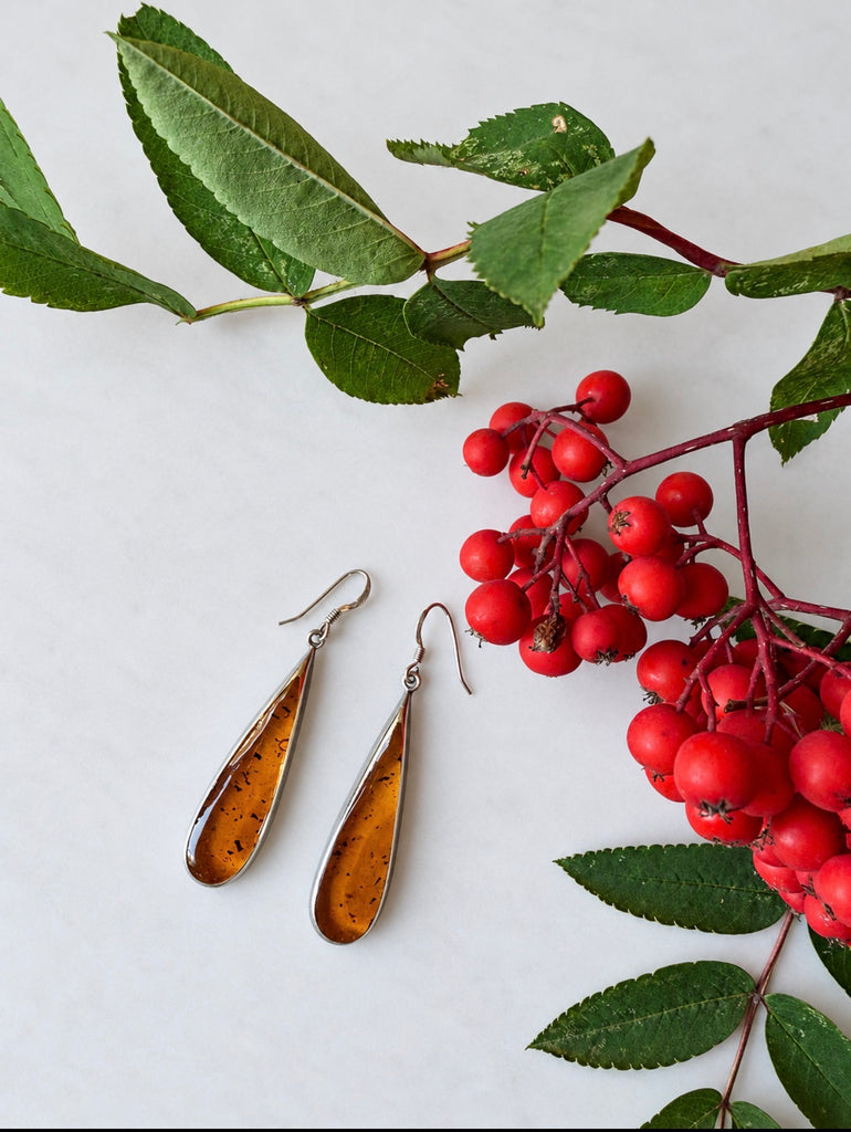 Mexican 925 sterling silver amber earrings displayed with green leaves and red berries