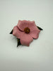 Angled view of handmade pink leather Wild Rose brooch showing dimensional petals and floral centre