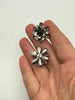 Vintage black enamel rhinestone earrings shown in hand for scale