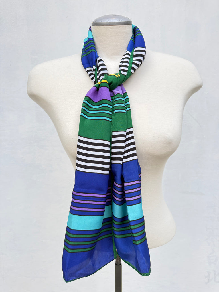 Vintage jewel tone striped scarf styled around the neck on mannequin. 