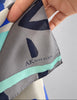 Close-up of "Anne Klein" printed on abstract blue grey and turquoise pattern