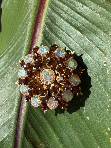 Vintage Aurora Borealis starburst brooch with amber and smoky topaz rhinestones on green leaf