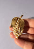 Vintage faux pearl grape cluster brooch shown in hand for scale