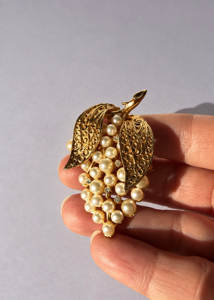 Vintage faux pearl grape cluster brooch shown in hand for scale