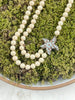 Heidi Daus double strand cream simulated pearl necklace with Swarovski crystal starfish pendant displayed outdoors