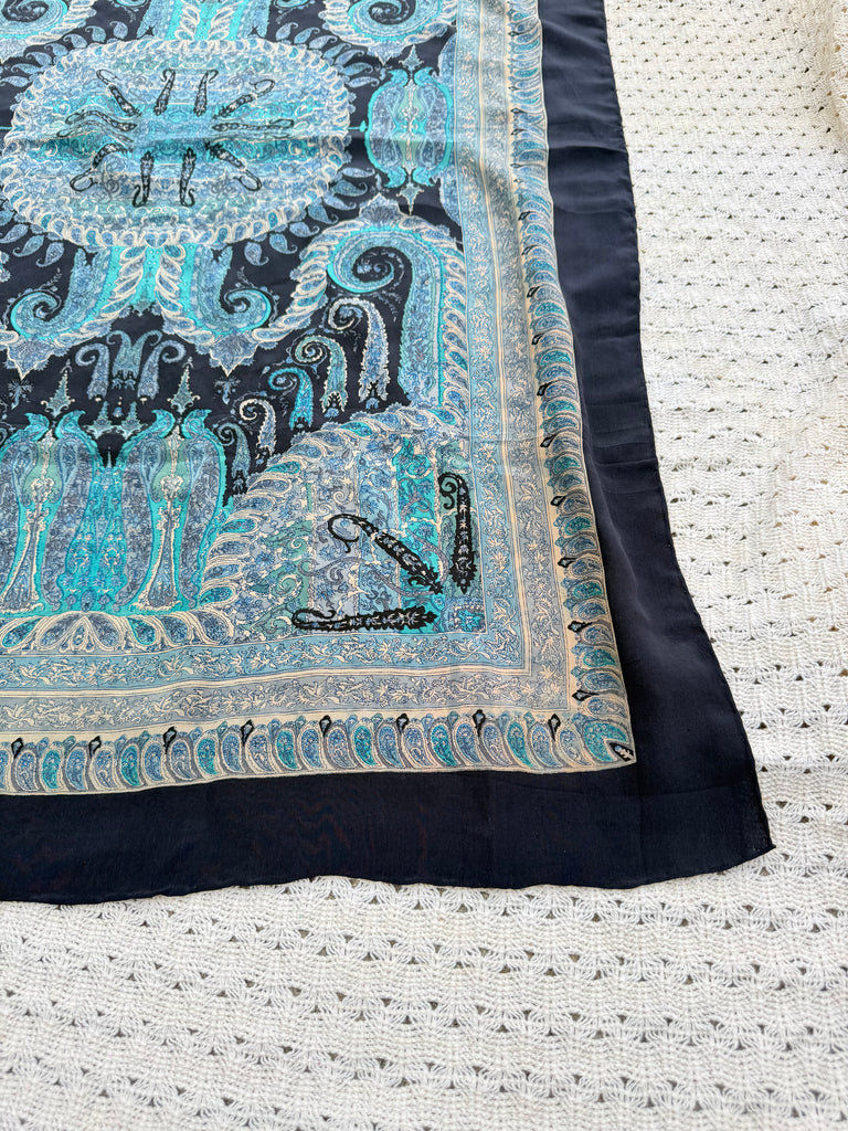 Close-up of turquoise paisley silk scarf with ornate border detailing