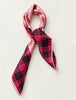 Pink and black checked square scarf tied in a neck scarf style