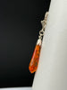 Side view of vintage Baltic amber drop earring showing faceted amber and silver setting