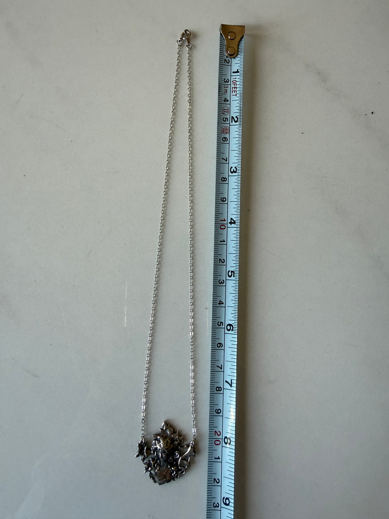 Sterling silver maiden pendant necklace photographed beside measuring tape