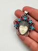Vintage Balinese carved face gemstone pendant shown in hand for scale