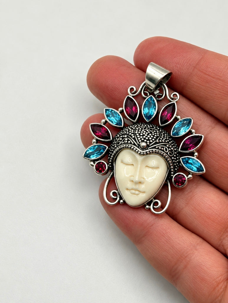 Vintage Balinese carved face gemstone pendant shown in hand for scale