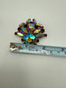 Vintage aurora borealis rhinestone brooch beside measuring tape showing approximately 2 inch width