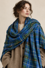 Woman wearing oversized Nova Scotia tartan scarf draped around shoulders