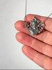 Close-up of sculptural ECCO silver pendant featuring woman's face 