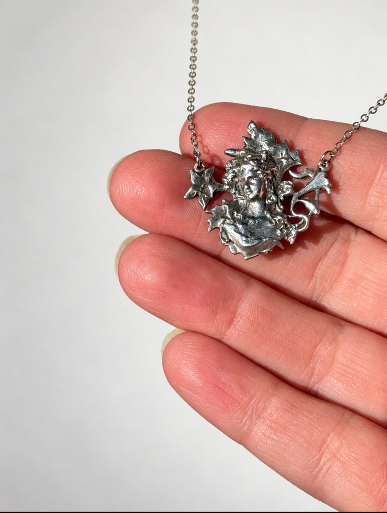 Close-up of sculptural ECCO silver pendant featuring woman's face 