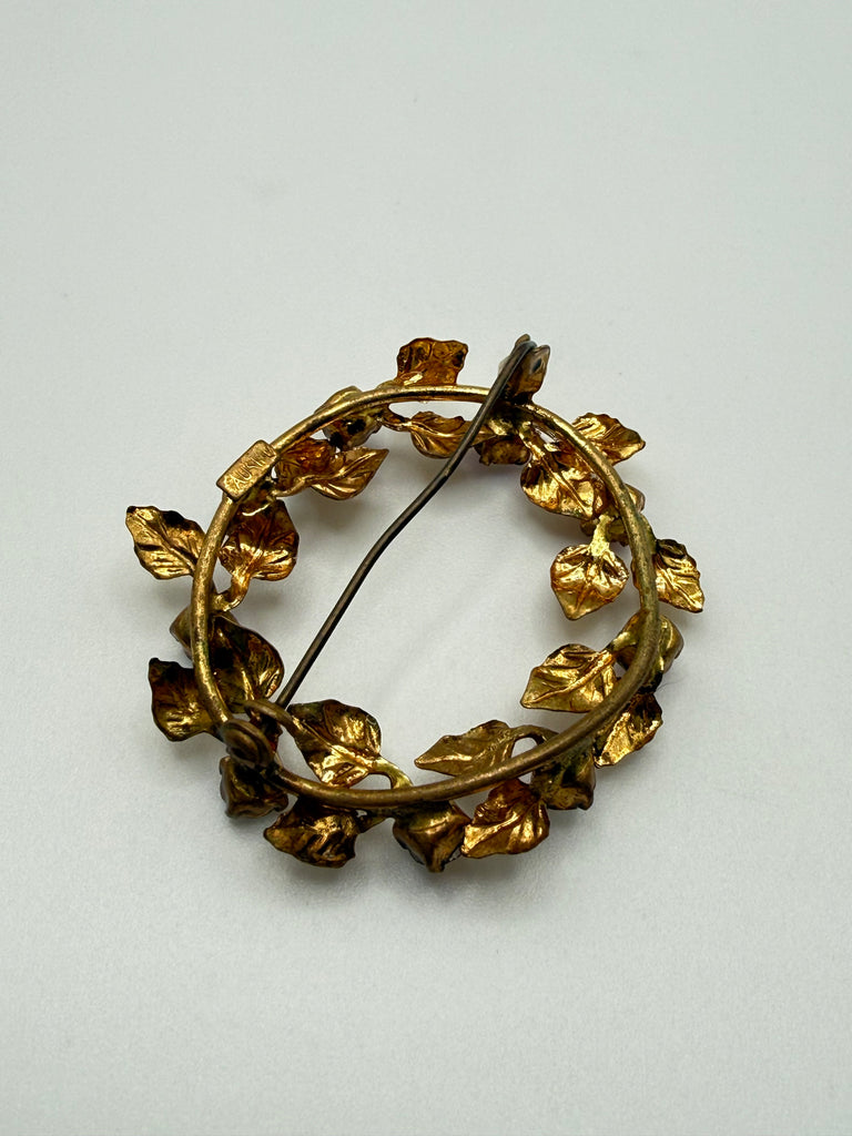 Back view of vintage Austrian wreath brooch showing gold-tone metal construction and pin closure