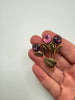 Vintage Austrian statement brooch shown in hand with pink purple crystals and textured gold-tone leaves