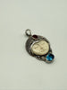Angled view of vintage Balinese silver pendant with carved cream portrait and colourful stone accents